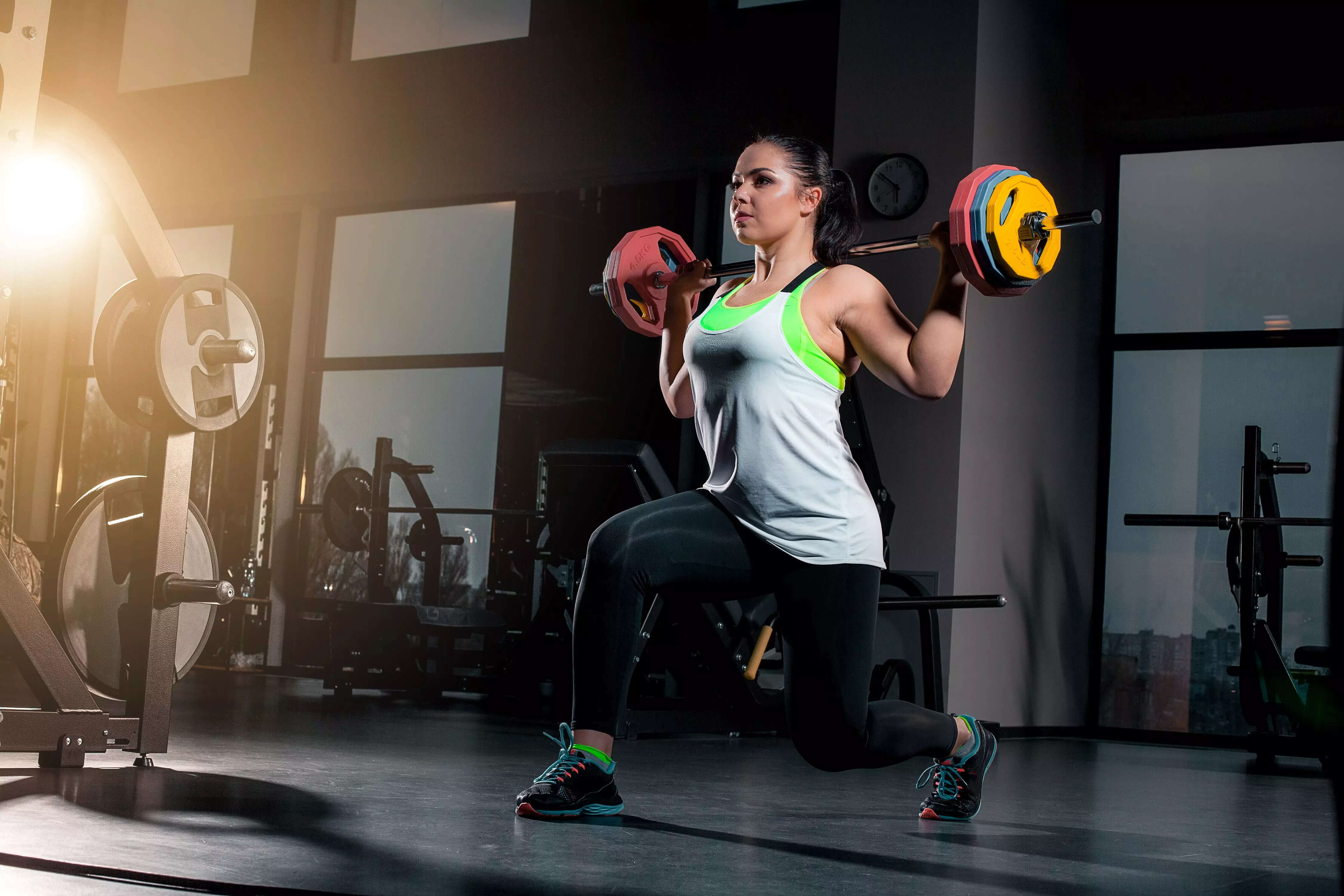fit-young-woman-lifting-barbells-looking-focused-working-out-gym 1