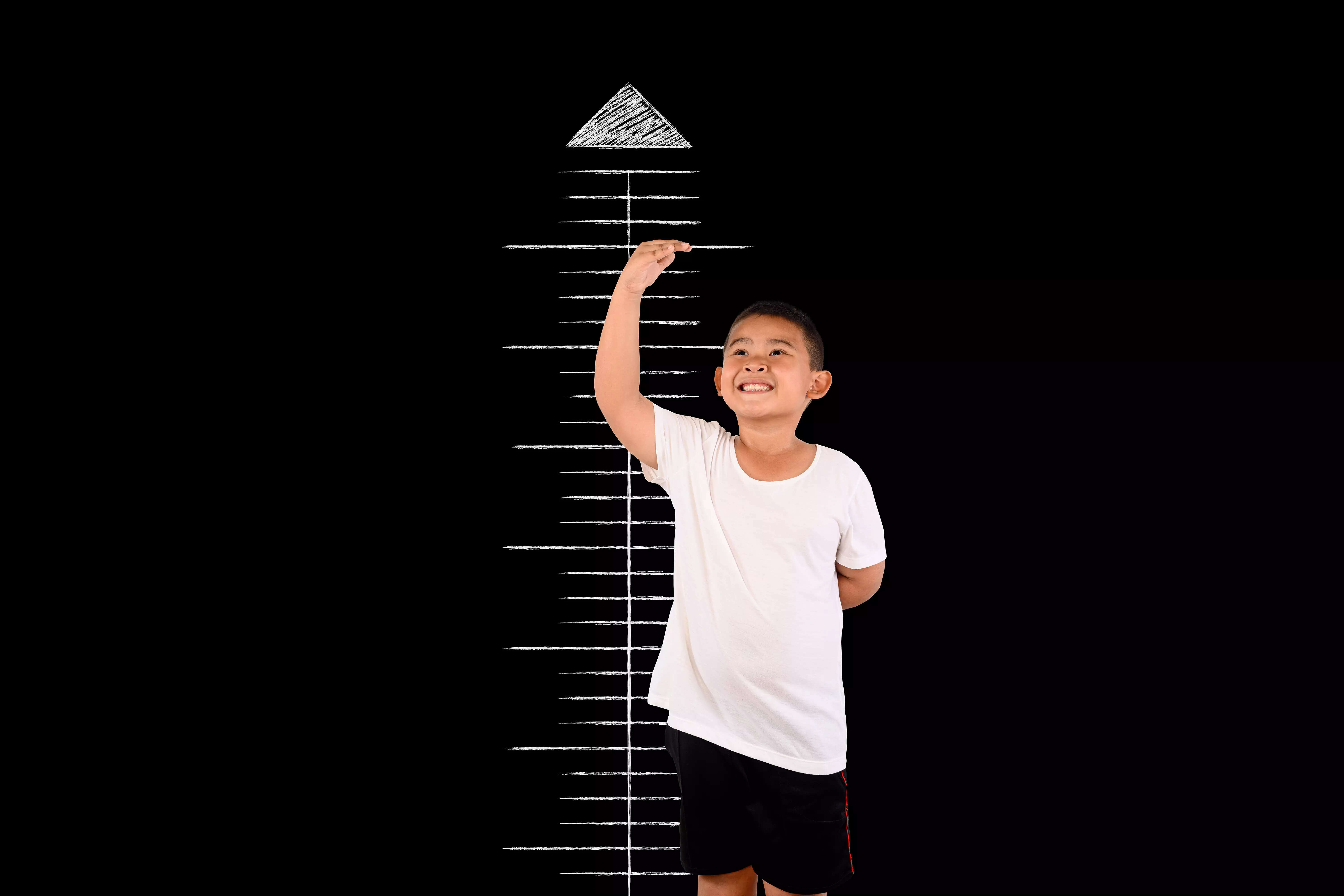 boy-measured-height-with-blackboard 1