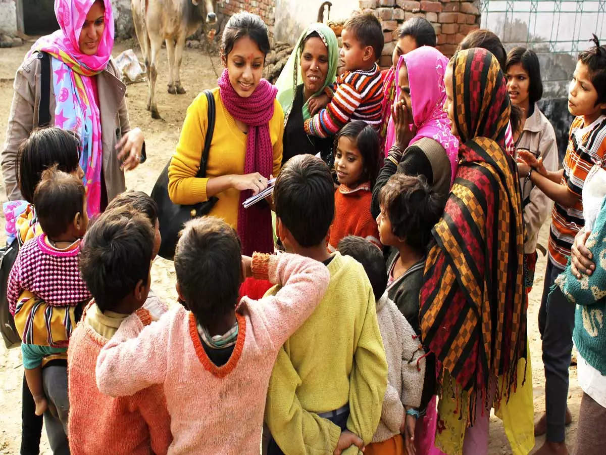 teacher talks to students in village