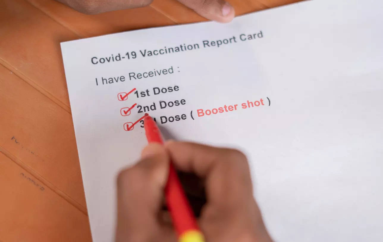 Hands checking Covid-19 vaccine report card