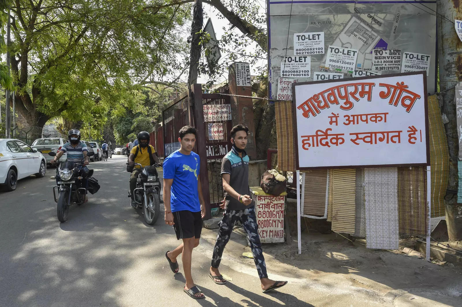 New Delhi: Locals near a board with the message ‘Welcome to Madhavpuram’ at the ...