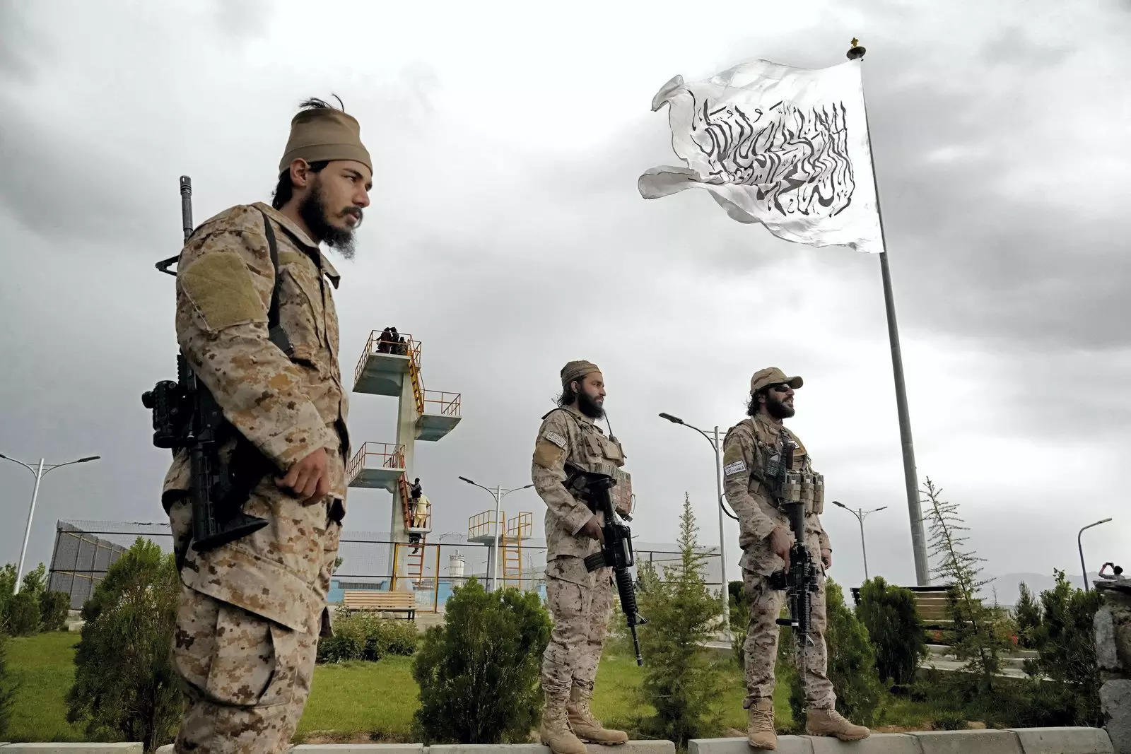 Taliban special forces stand guard in front of the Taliban flag