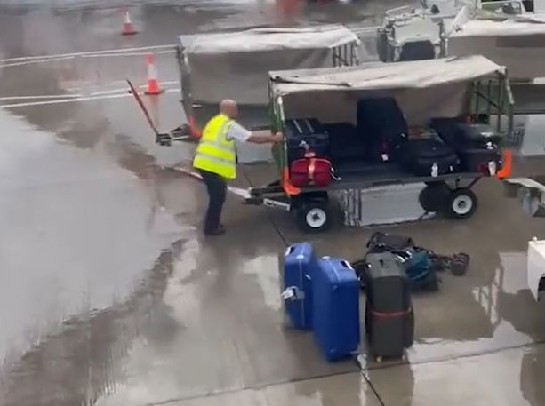 A co-pilot helps a lone baggage handler load his bags onto the plane after a 30-hour delay cheered on by passengers