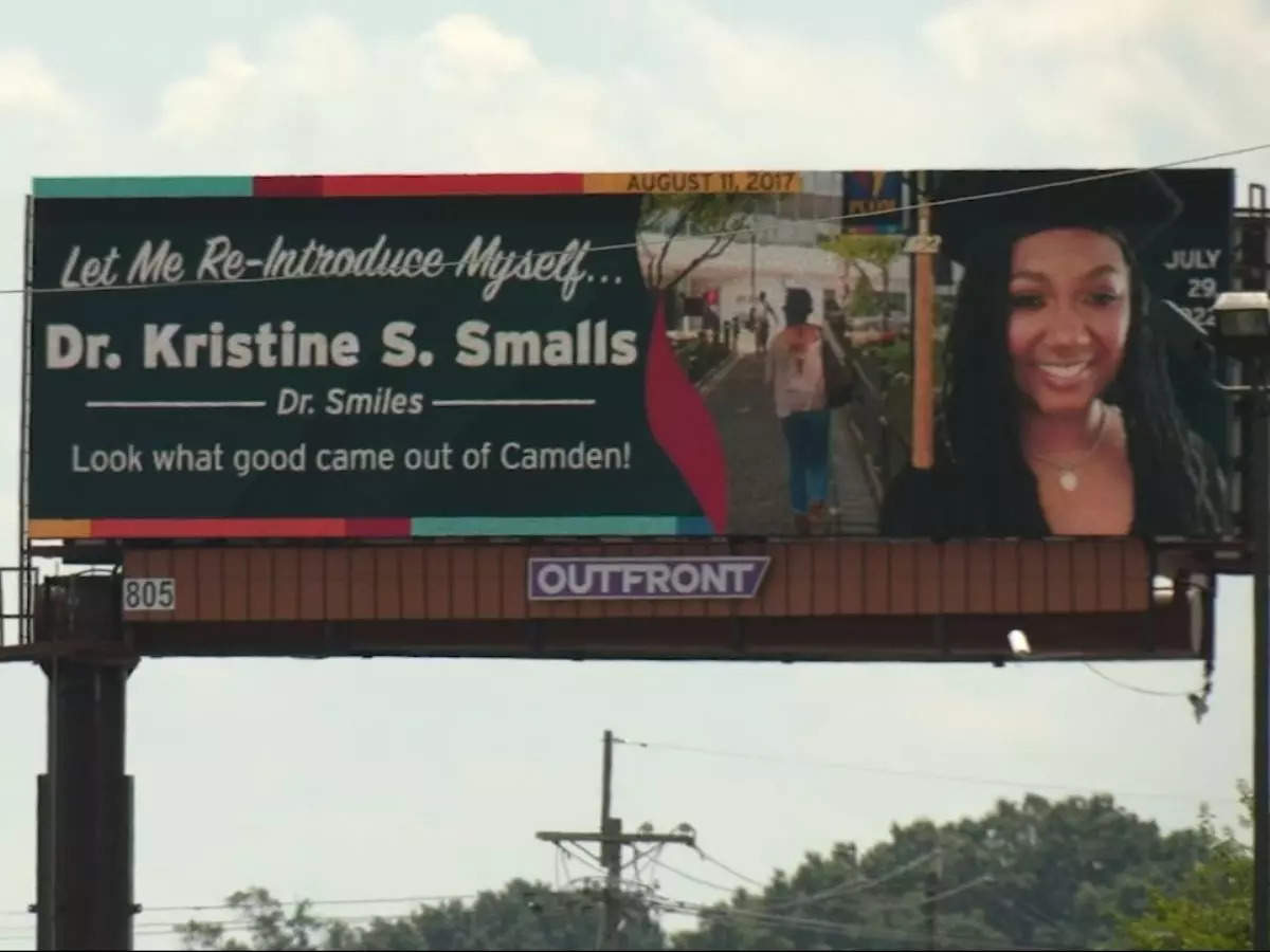 A hoarding congratulating Dr. Kristine S. Smalls on receiving her doctorate sits over a busy street in Camden, New Jersey