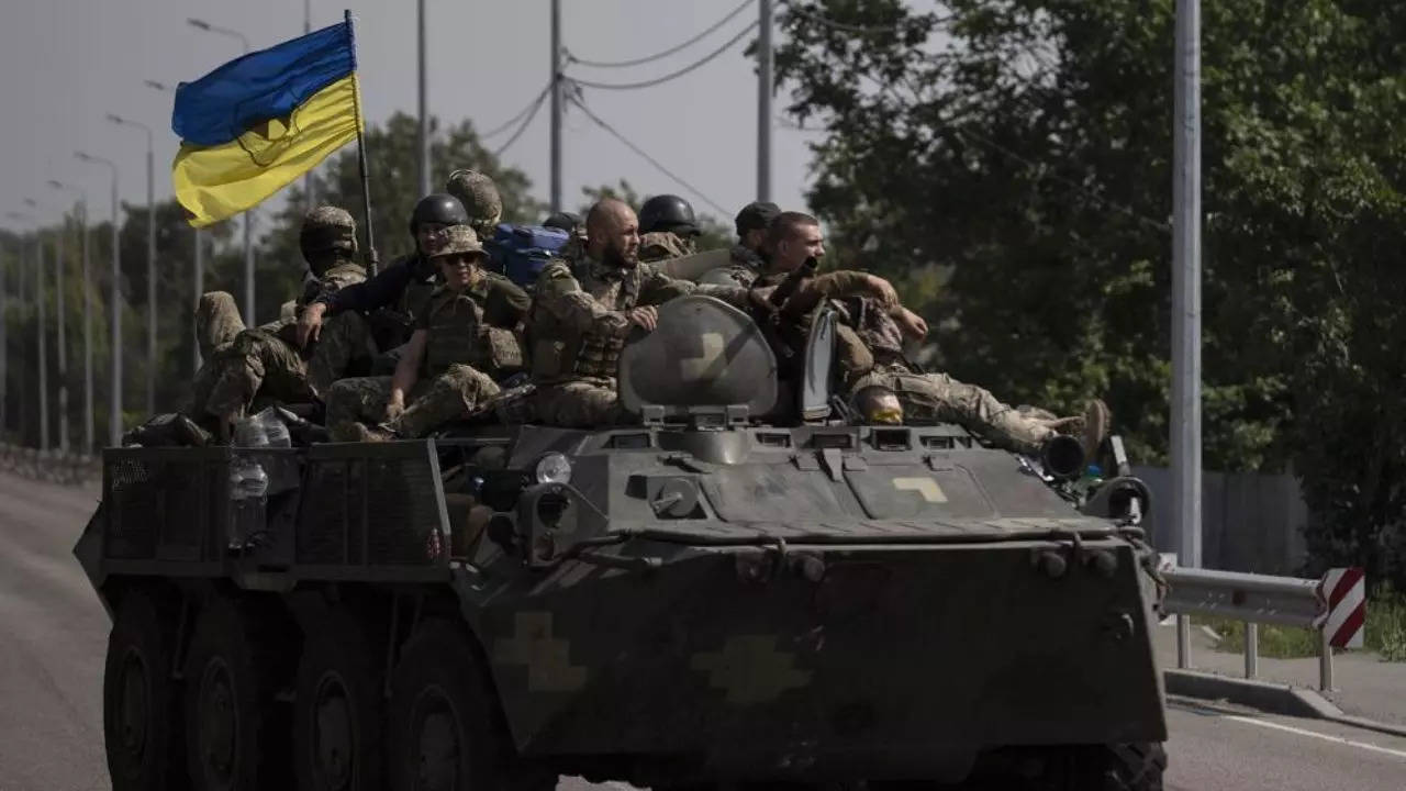 Ukrainian servicemen ride atop of an armoured vehicle in Donetsk region