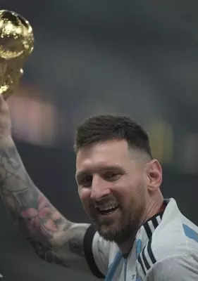 Lusail:Argentina's Lionel Messi celebrates with the trophy after winning the World Cup final soccer match between Argentina and France at the Lusail Stadium in Lusail, Qatar, Sunday, Dec.18, 2022 .(Photo:Suman Chattopadhyay/IANS)