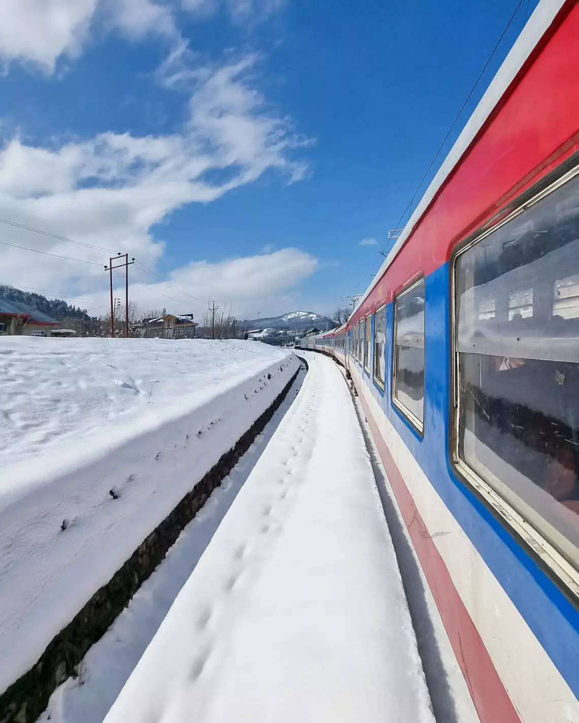 Train passes through snow-covered station