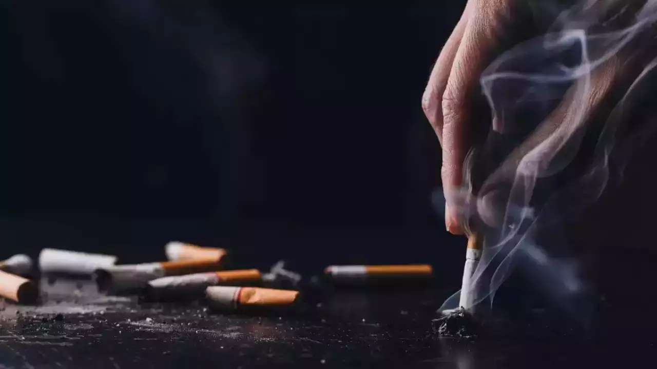A hand crushing a cigarette
