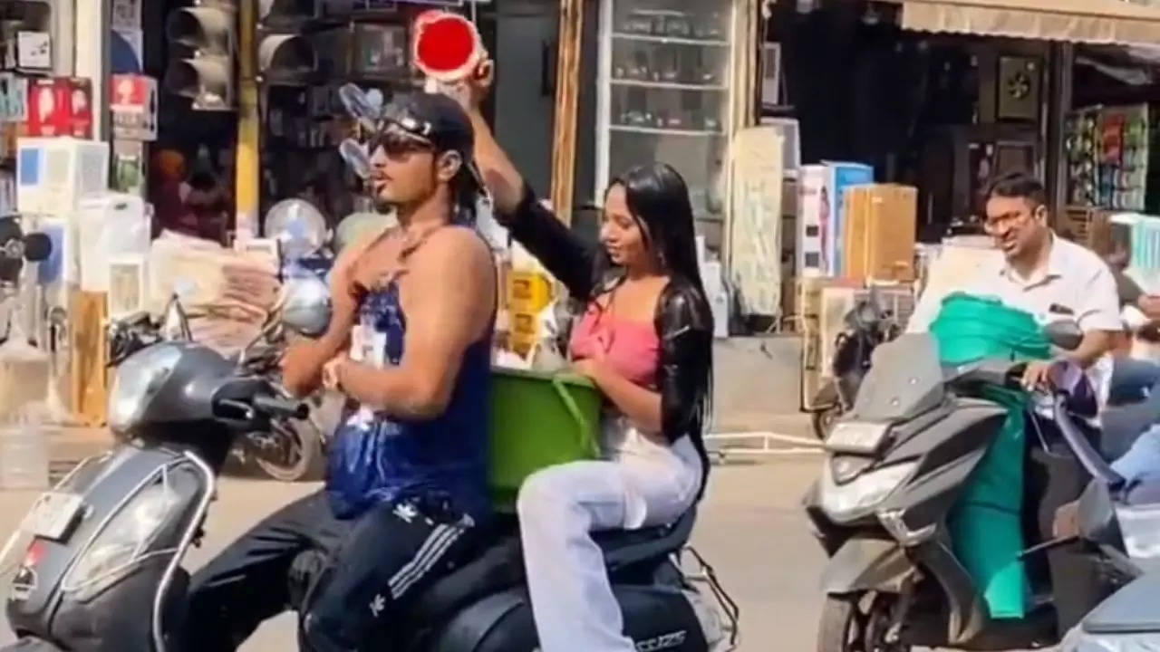 Couple takes a 'bath' while riding a scooter in Ulhasnagar, Thane | Screenshot via @ItsAamAadmi/Twitter