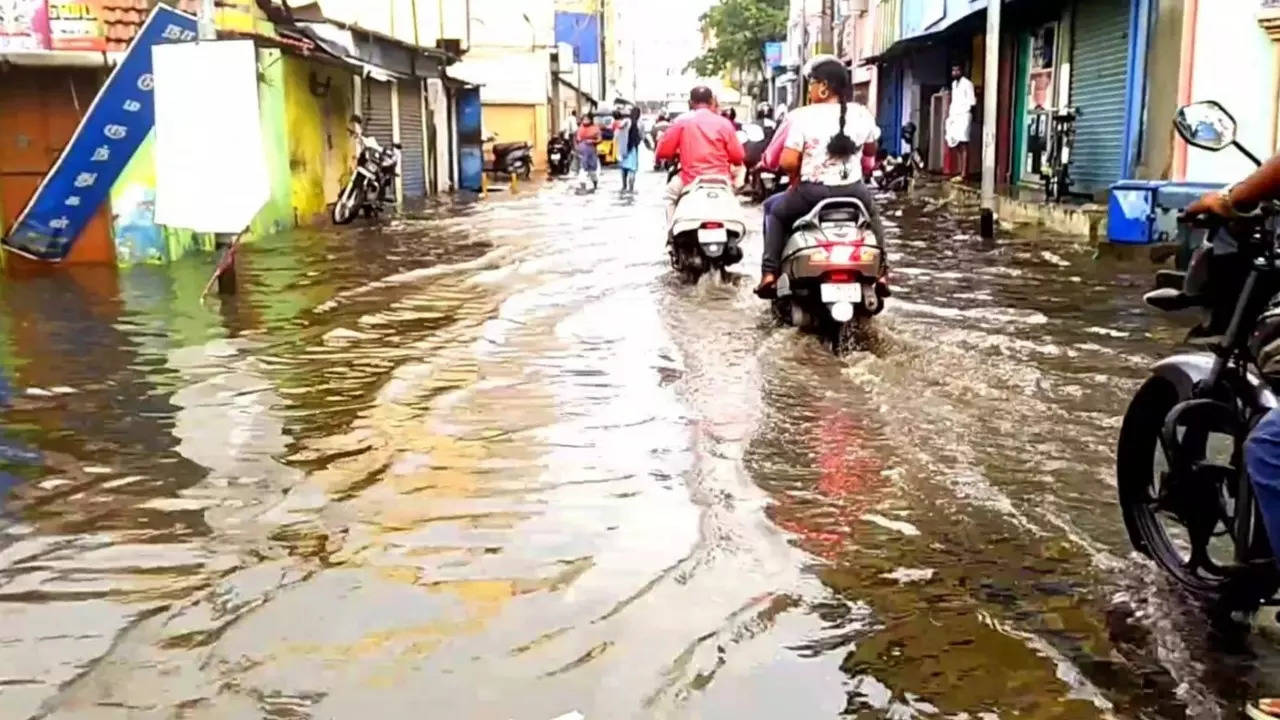 Commuters drive through ankle-deep water in Coimbatore after heavy rain on Friday