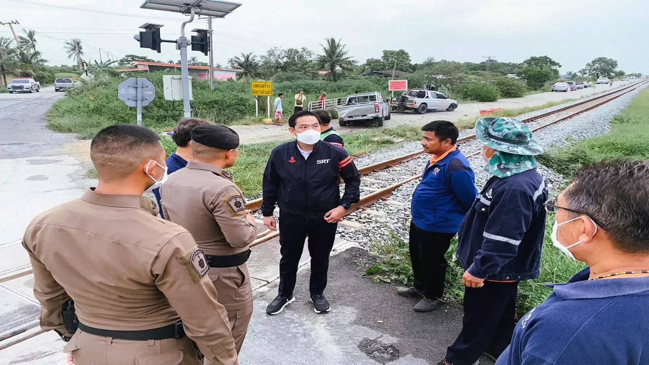 Caption: Gov. of the State Railway of Thailand Nirut Maneepan talks to police at a crash site in Muang, Chachoengsao province, Thailand.