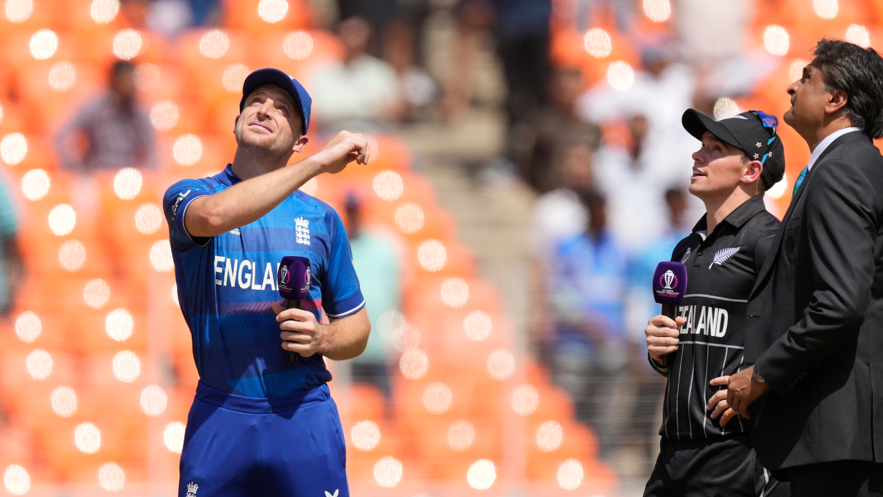 England's captain Jos Butler poses a coin for toss as New Zealand's stand in captain Tom Latham, second right, watches during the ICC Cricket World Cup opening match between England and New Zealand in Ahmedabad, India, Thursday, Oct. 5, 2023. (AP Photo/Ajit Solanki)