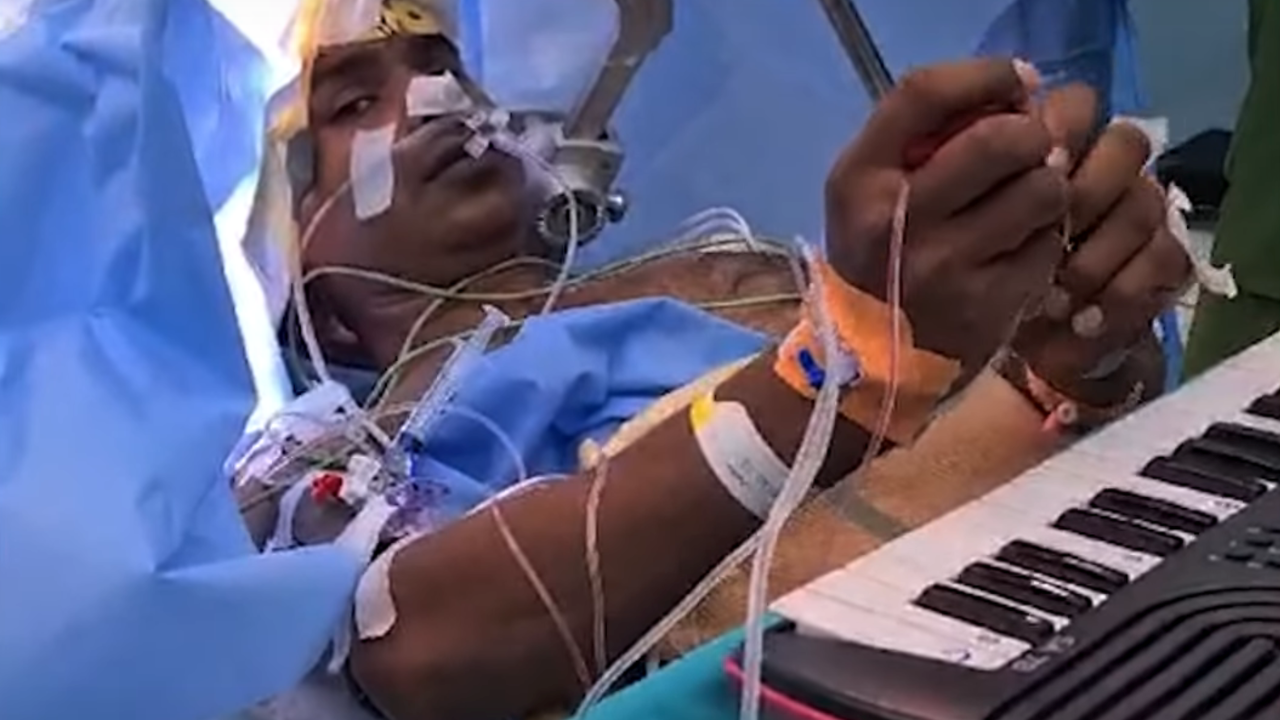 A patient undergoing brain tumour removal surgery plays music at AIIMS Bhopal.