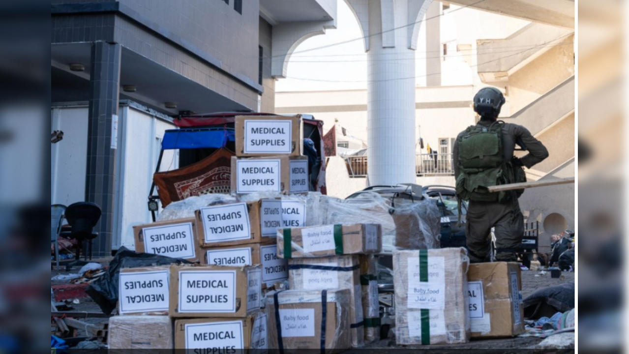 Israeli soldier stands guard as medical supplies arrive at al Shifa hospital