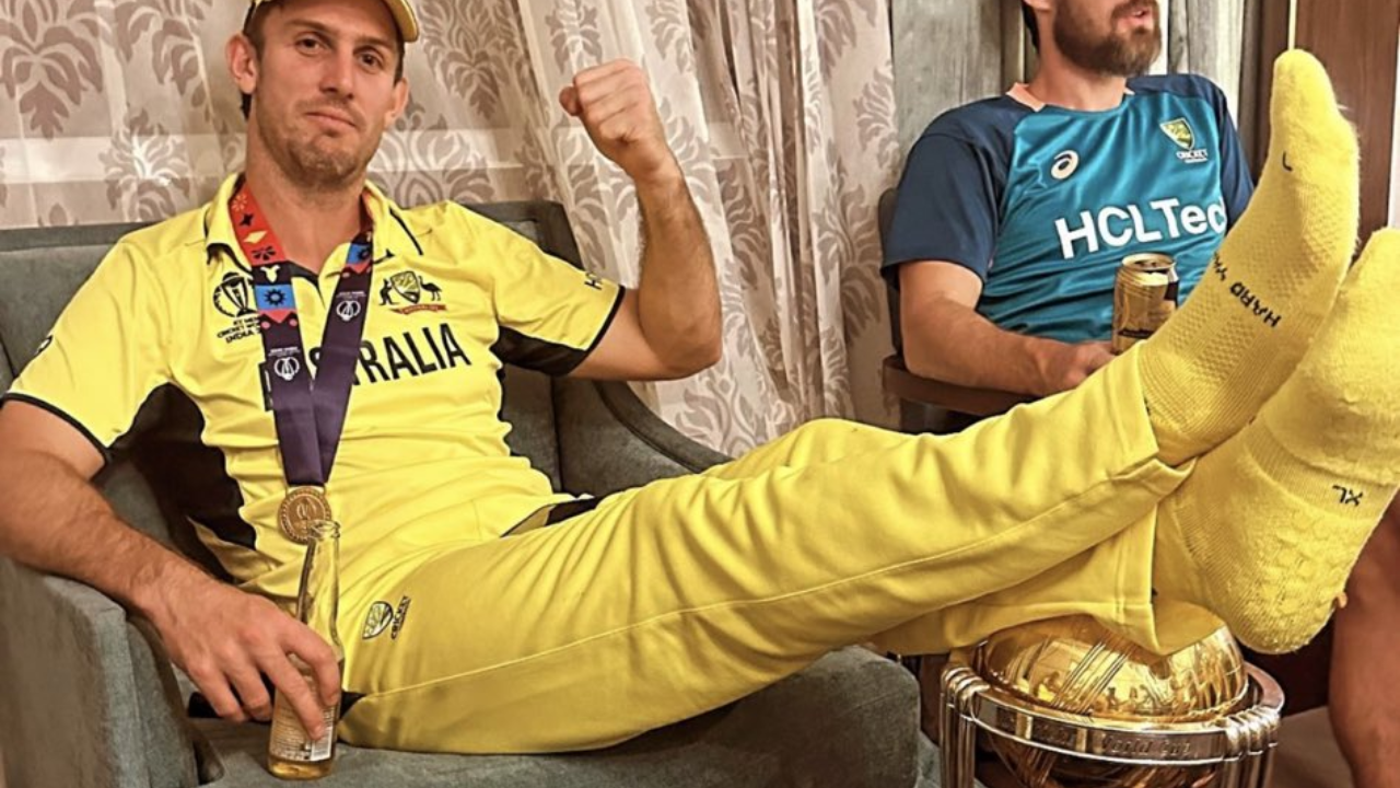 Australia’s Mitchell Marsh rests feet on World Cup trophy after defeating India.
