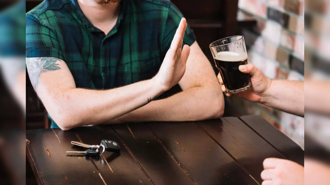 man-refusing-glass-rum-offered-by-his-friend