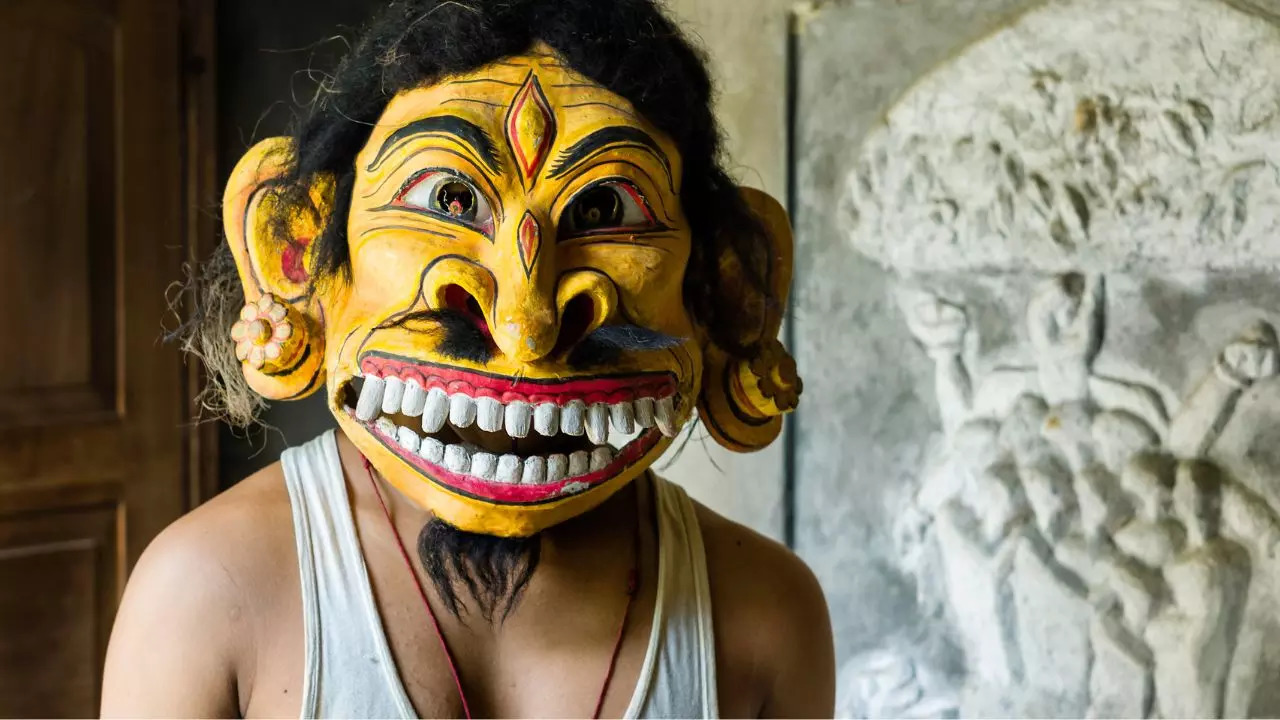 A hindu monk wears a traditional ceremonal mask at a monastery on Majuli island. Credit: iStock