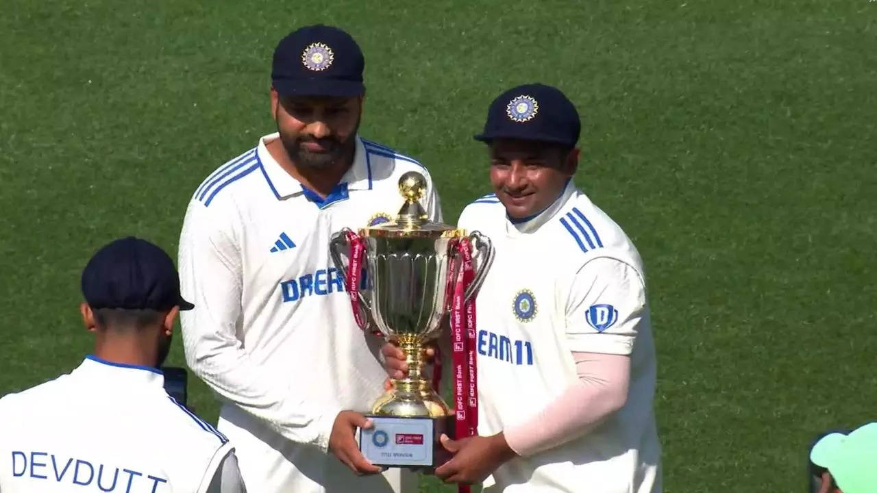 Rohit Sharma and Sarfaraz Khan pose with the trophy after Test series win against England on Saturday.