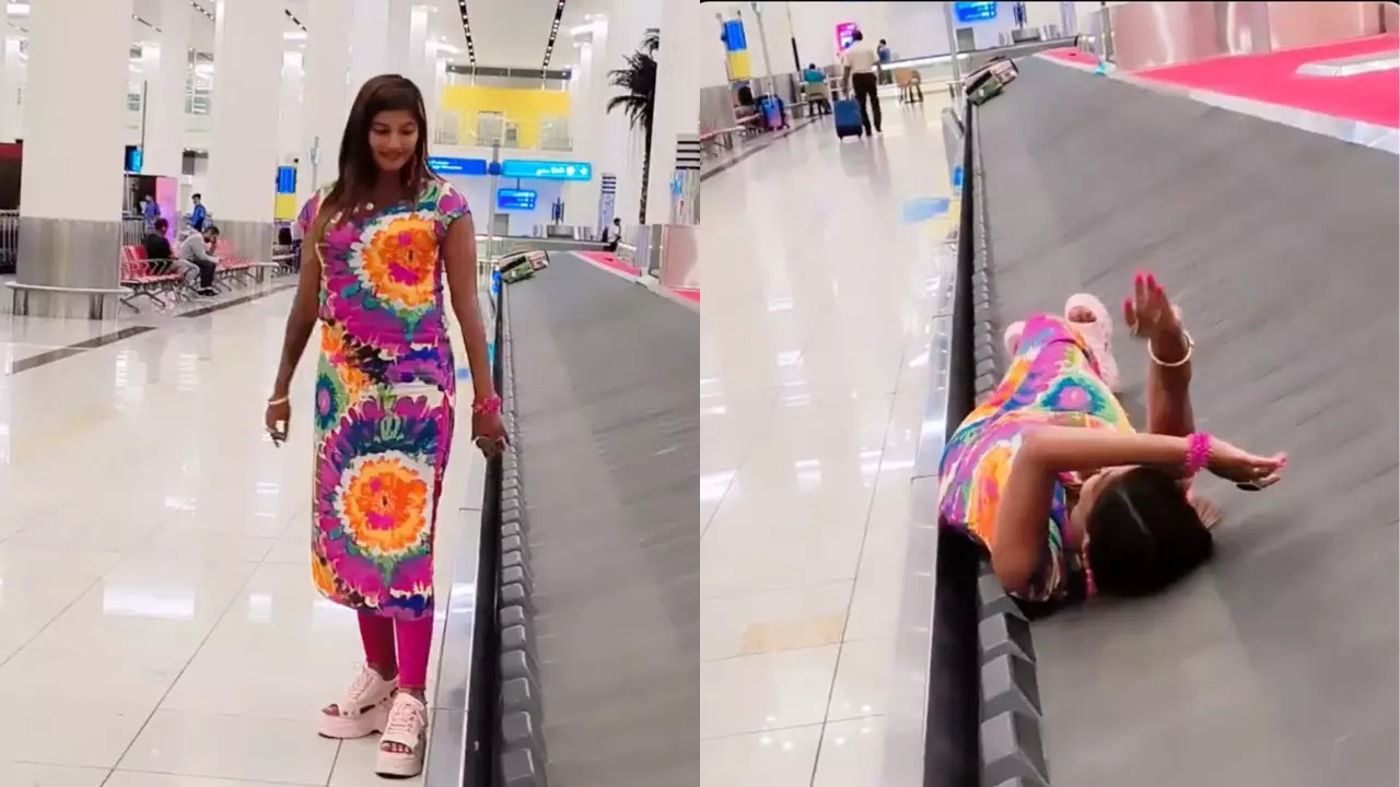 A woman lays on a baggage carousel at Dubai International Airport. | @desimojito/X