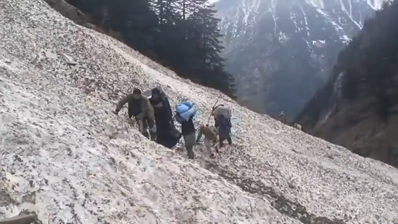 A polling party in the state of Jammu and Kashmir can be seen carrying equipment during an avalanche in the state. (Photo: Screengrab/X)