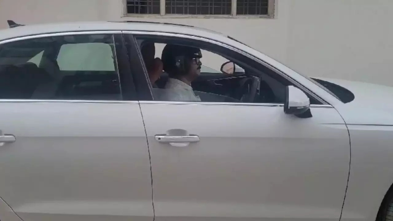 Bahadur Singh Parihar wears a helmet while driving his car due to inaction over his challan.