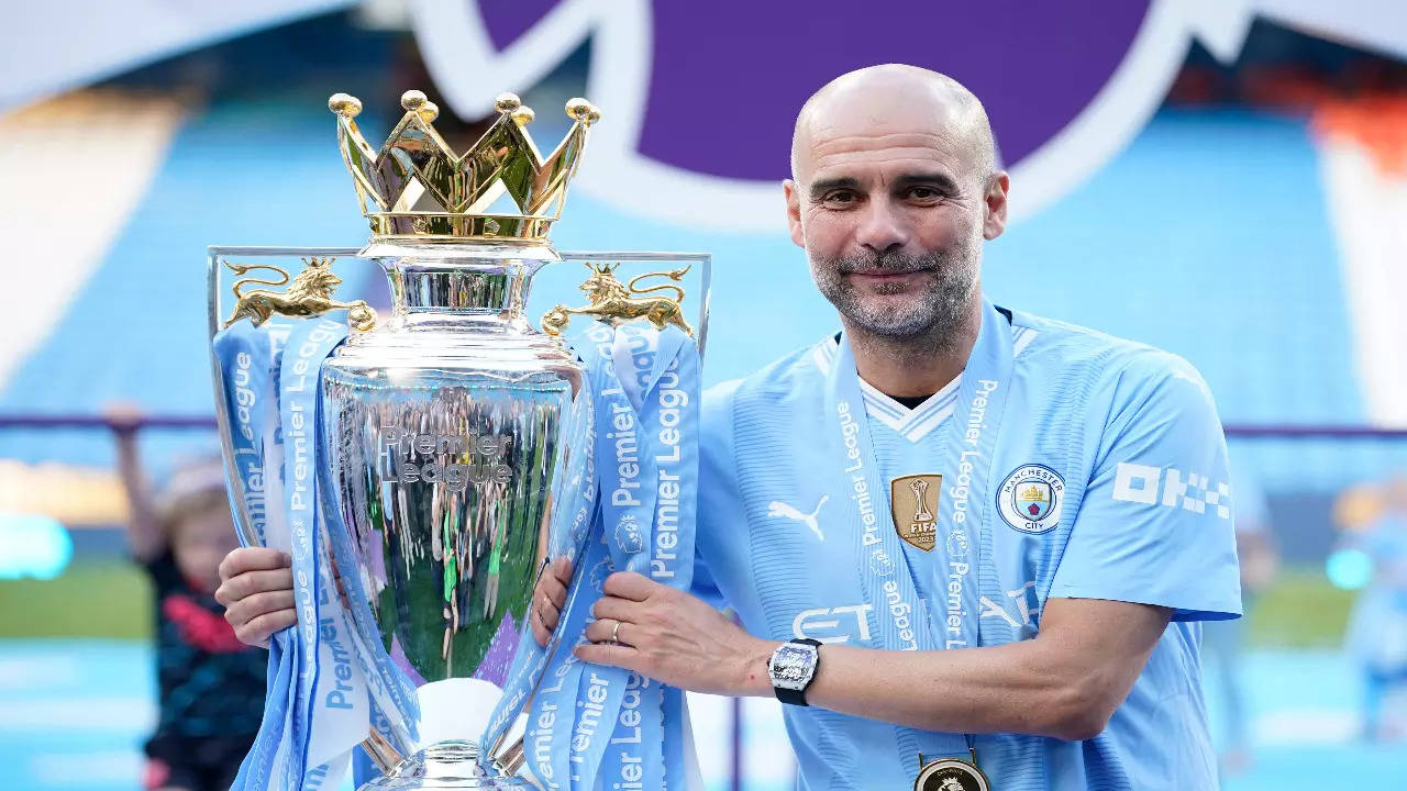 Pep Guardiola holds the Premier League trophy