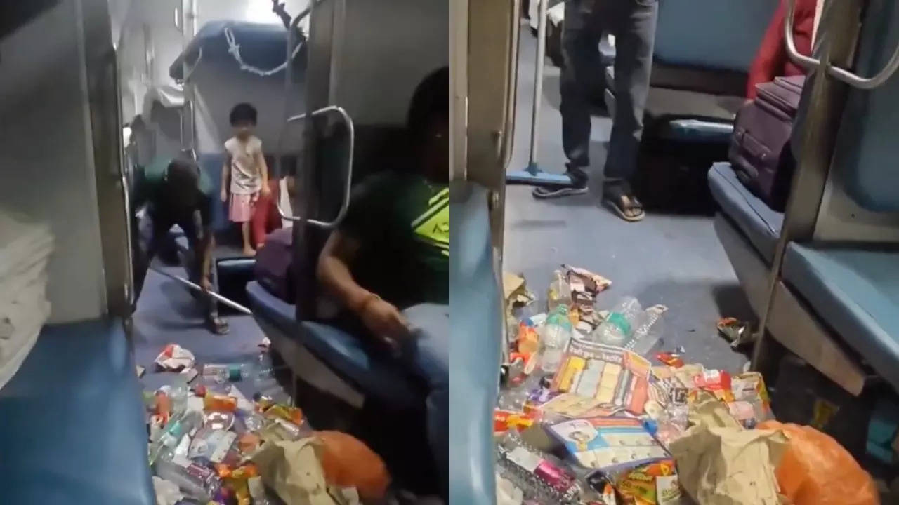 A Railways janitor cleans garbage from under the seats on a train. | Courtesy: Just Indian Things