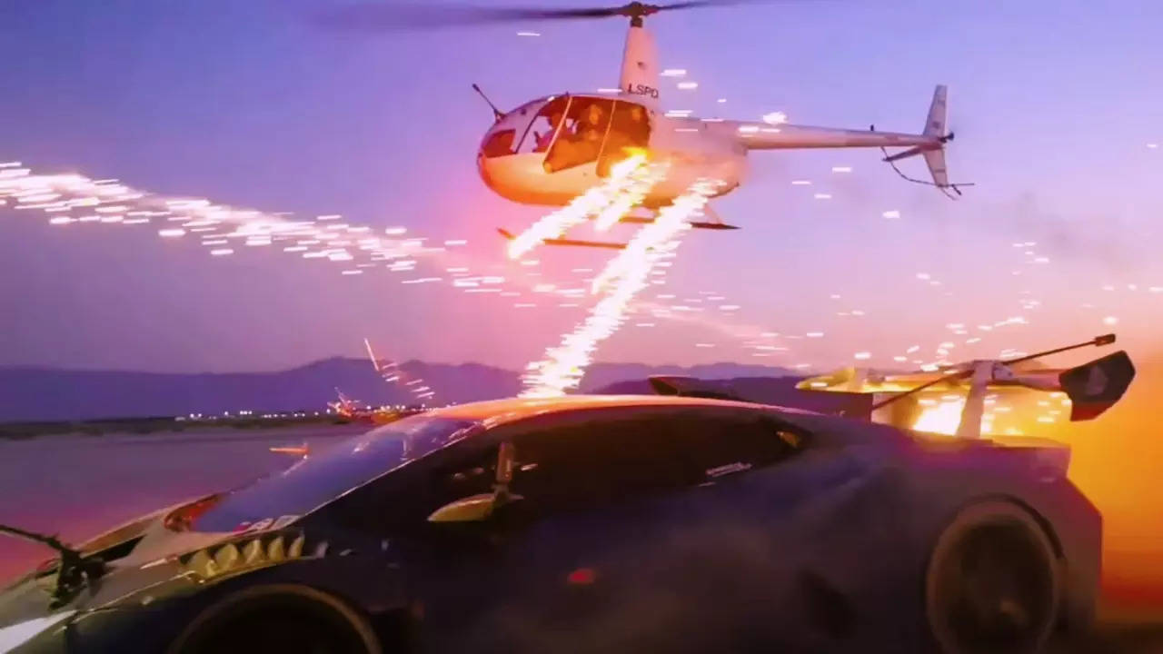 Two women on a low-flying helicopter shoot a Lamborghini with fireworks. | Alex Choi\YouTube