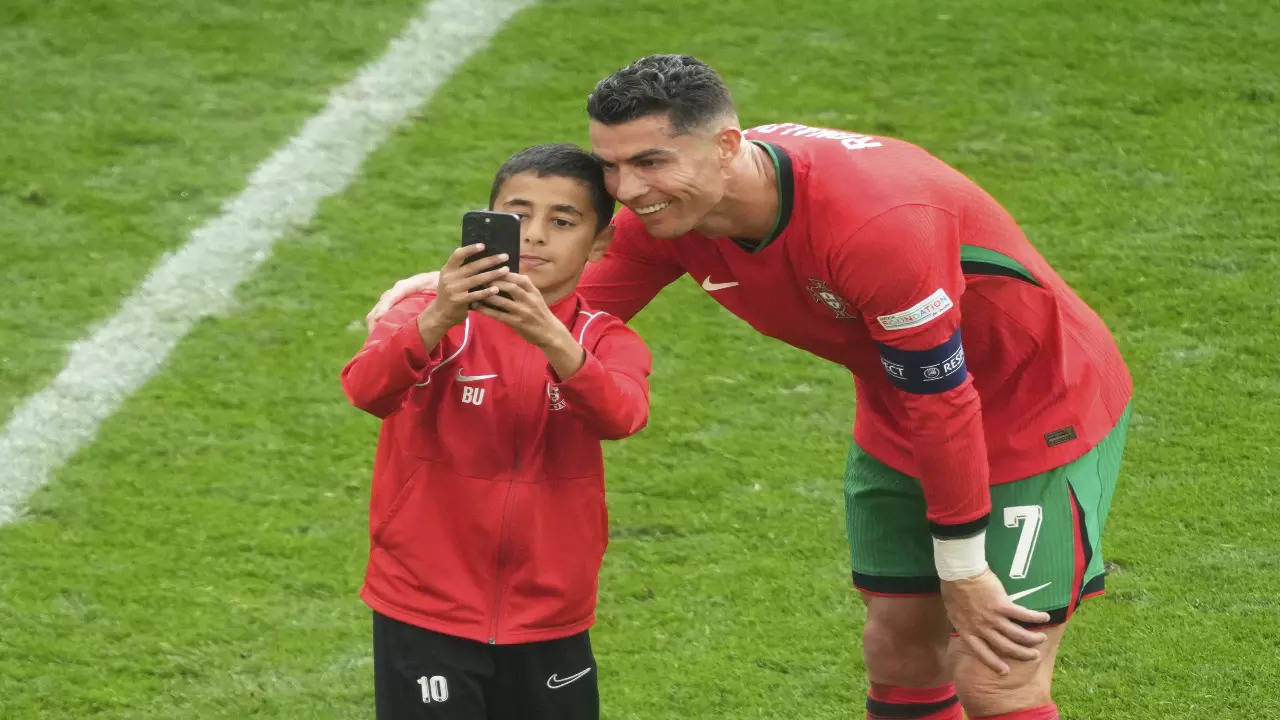 Cristiano Ronaldo takes a selfie with a fan