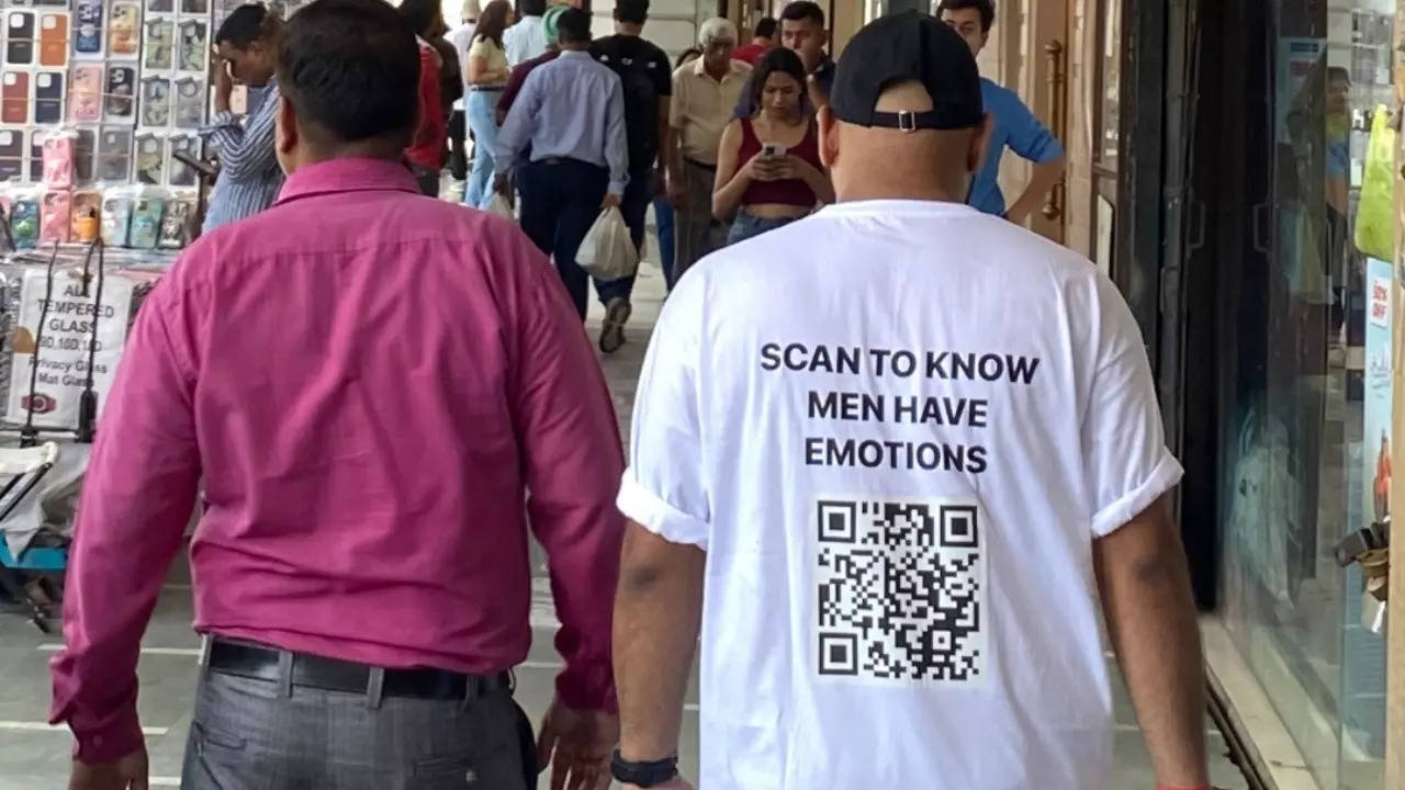 The QR code on a man's t-shirt leads to Rohit Saluja's fundraiser for his barber. | @poojaasanwal/X