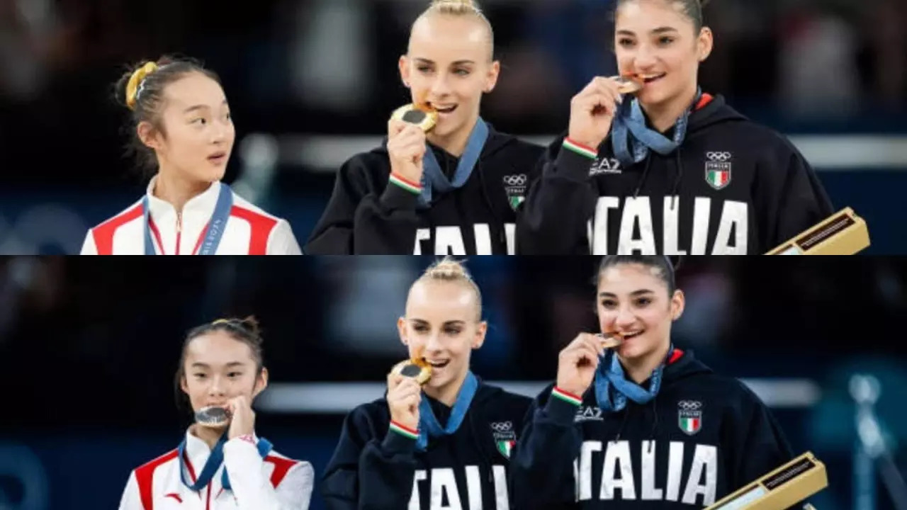 Chinese gymnast Zhou Yaqin bites her silver medal at the Paris Olympics balance beam podium.