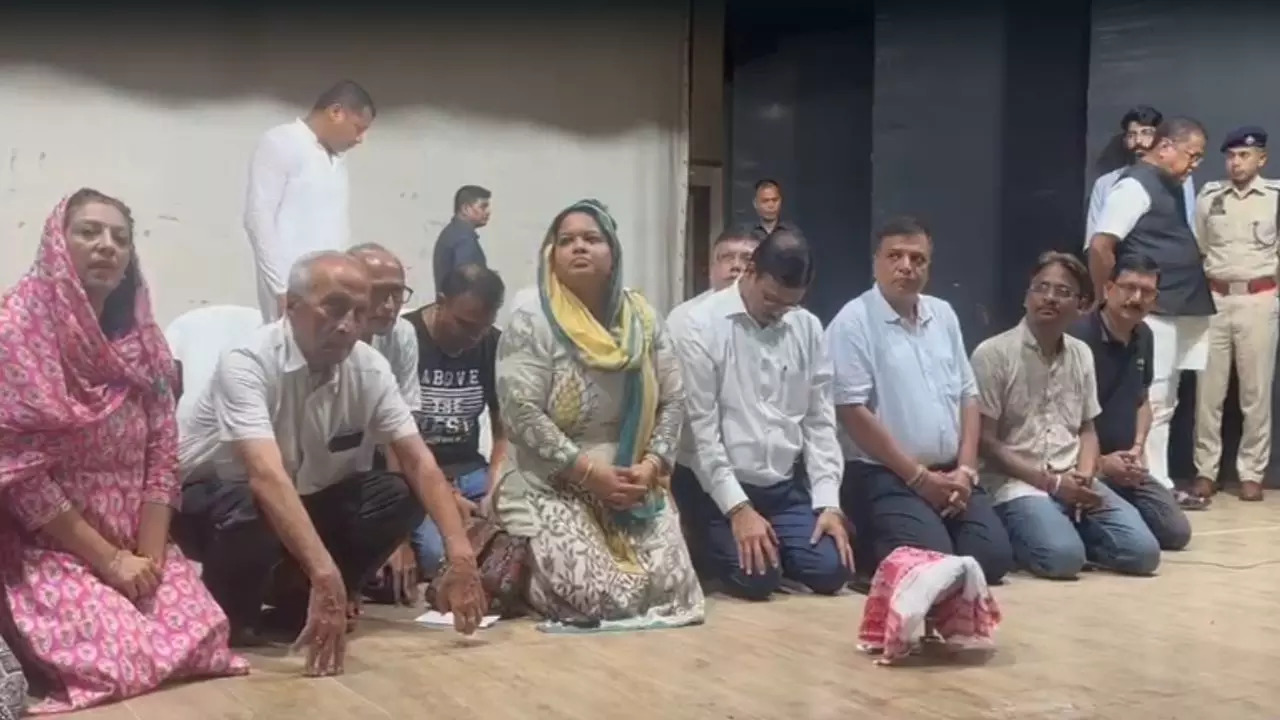 Members of the Marwari community kneel down in apology