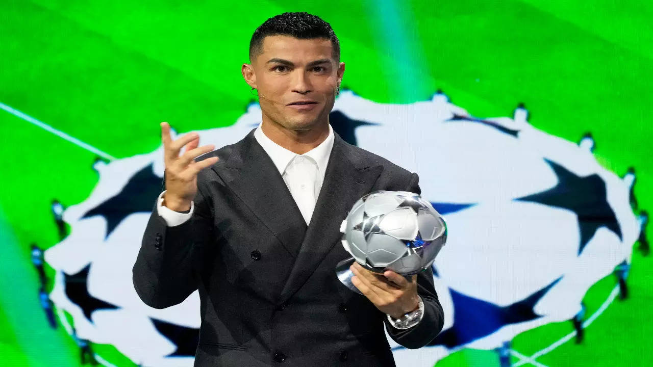 Cristiano Ronaldo posing with his special UCL award