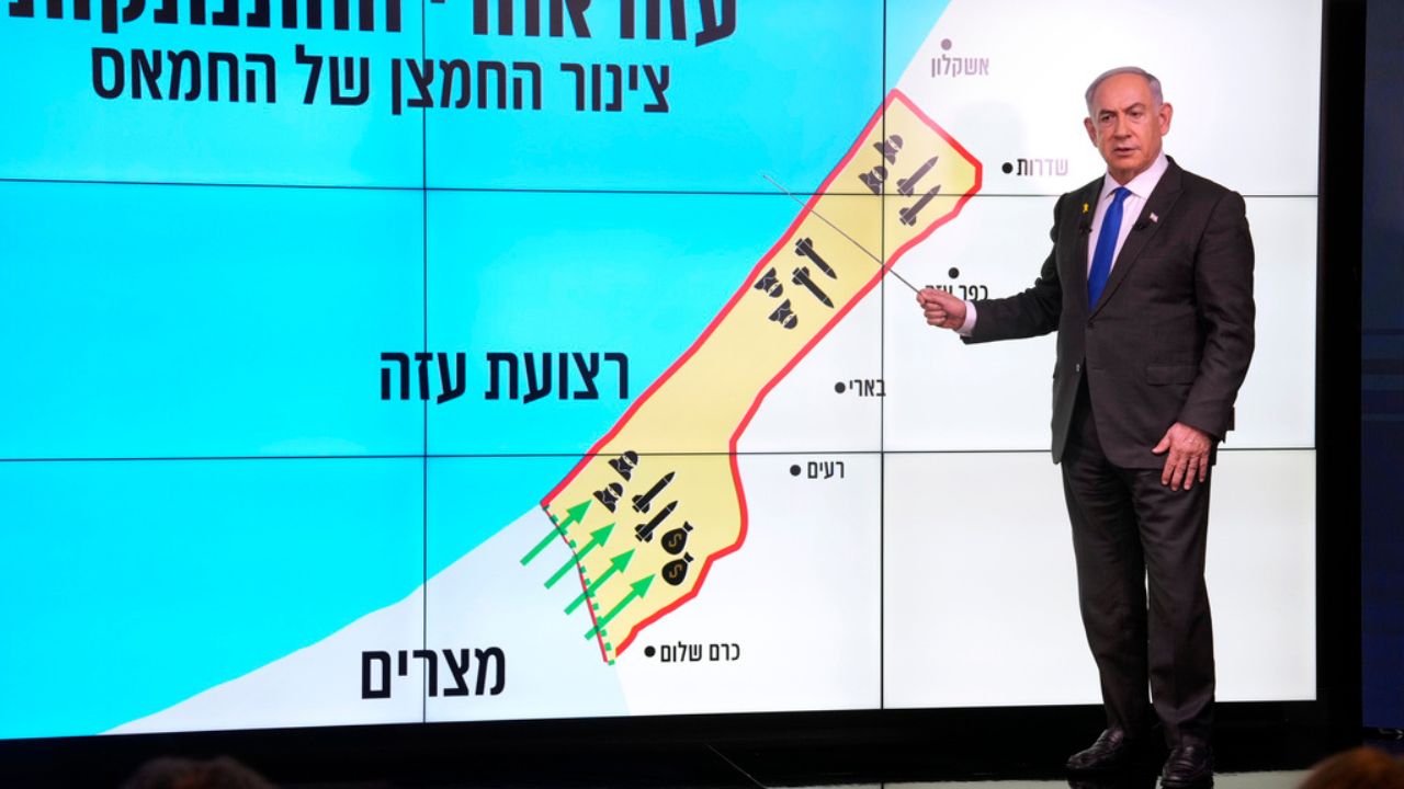 Israeli Prime Minister Benjamin Netanyahu stands before a map of the Gaza Strip