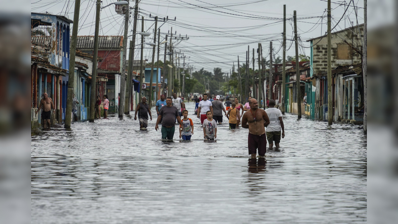 People Walk In Flooded Streets After Hurricane Creates Havoc