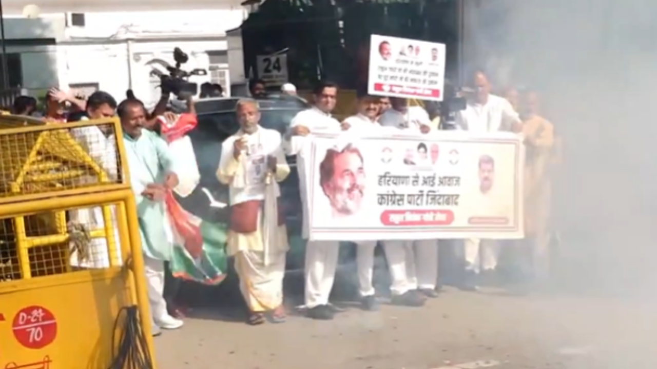 Workers celebrate outside Congress' Delhi office