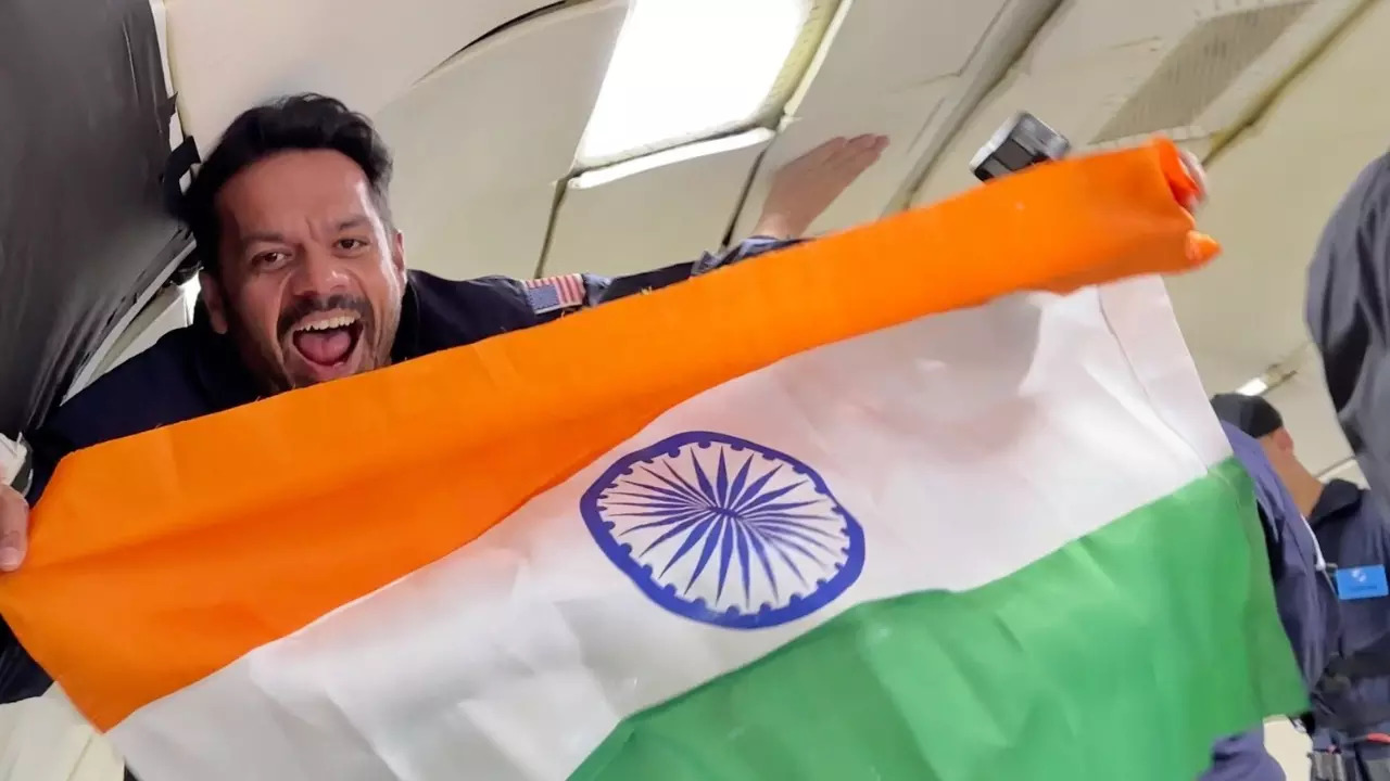 Gaurav Taneja unfurls the Indian flag on a zero-gravity flight. | Image courtesy: Flying Beast