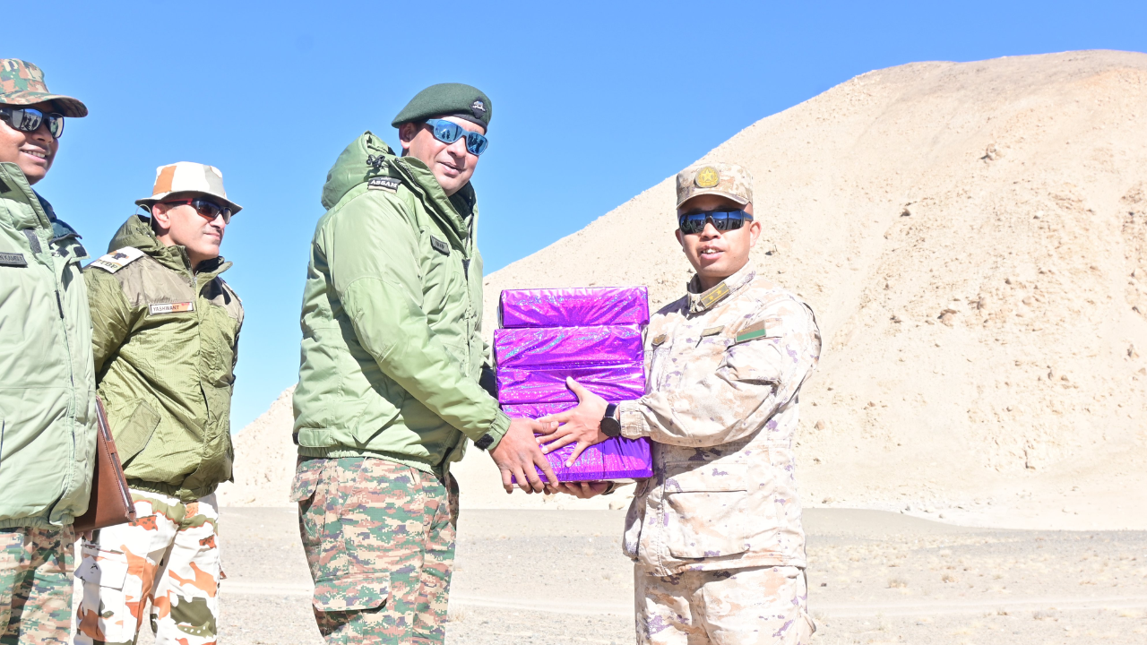 Soldiers of the Indian and Chinese Army exchange sweets at the Chushul-Moldo border meeting point on the occasion on Diwali