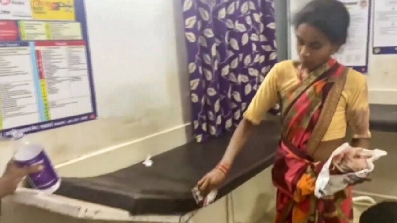 A pregnant woman cleans her husband's blood-stained hospital bed after his death in Dindori.