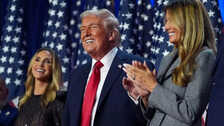 Who is the beautiful woman in black on the stage with Donald Trump?