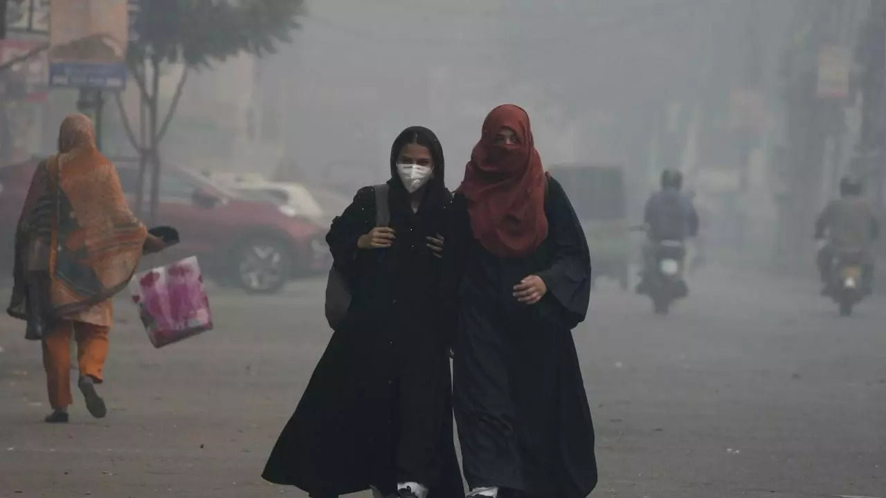 Students wear mask and heading to their school as smog envelops the areas of Lahore, Pakistan