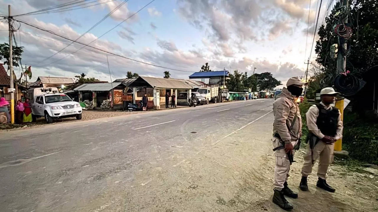 Police personnnel stand guard along the Imphal-Moirang road at Ningthoukhong town in Manipur’s Bishnupur district