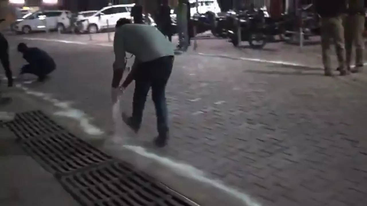 Lime being sprinkled alongside the entry to the hospital