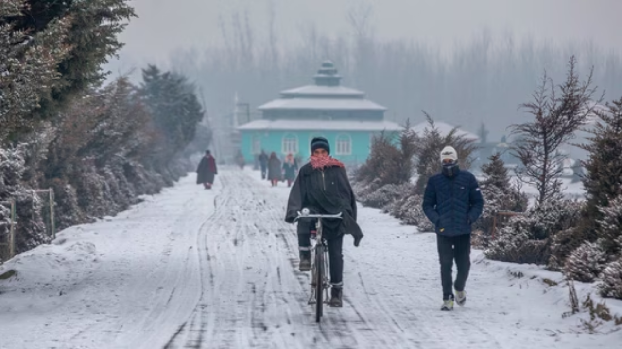 A cyclists rides on a slippery snow covered road after a brief snowfall in Srinagar