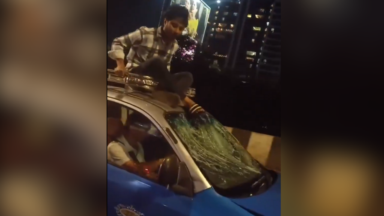 Man sits on the roof of taxi driver