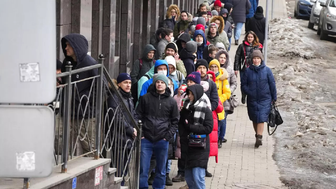 People stand in line to withdraw US dollars and Euros from an ATM in St. Petersburg on February 25, 2022.