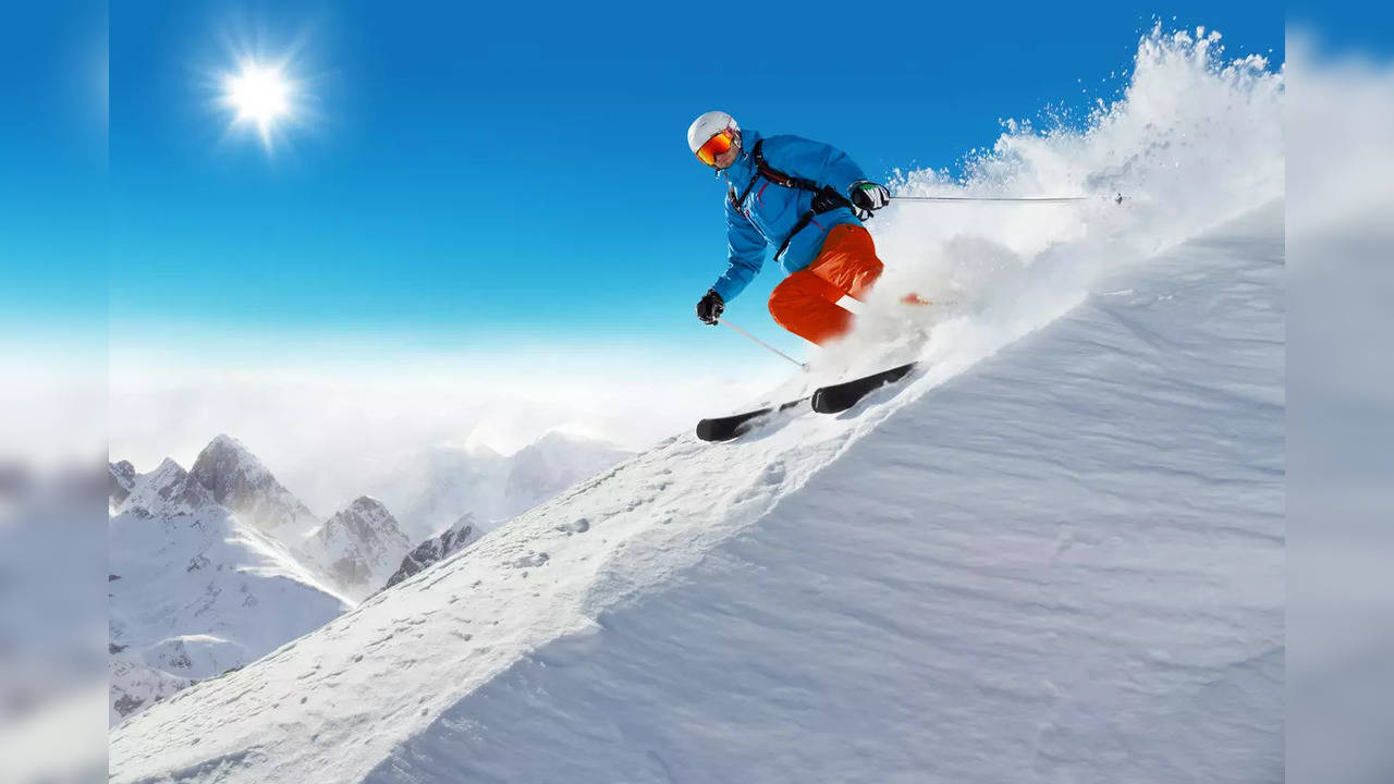 Skier skiing downhill over snowladen slope