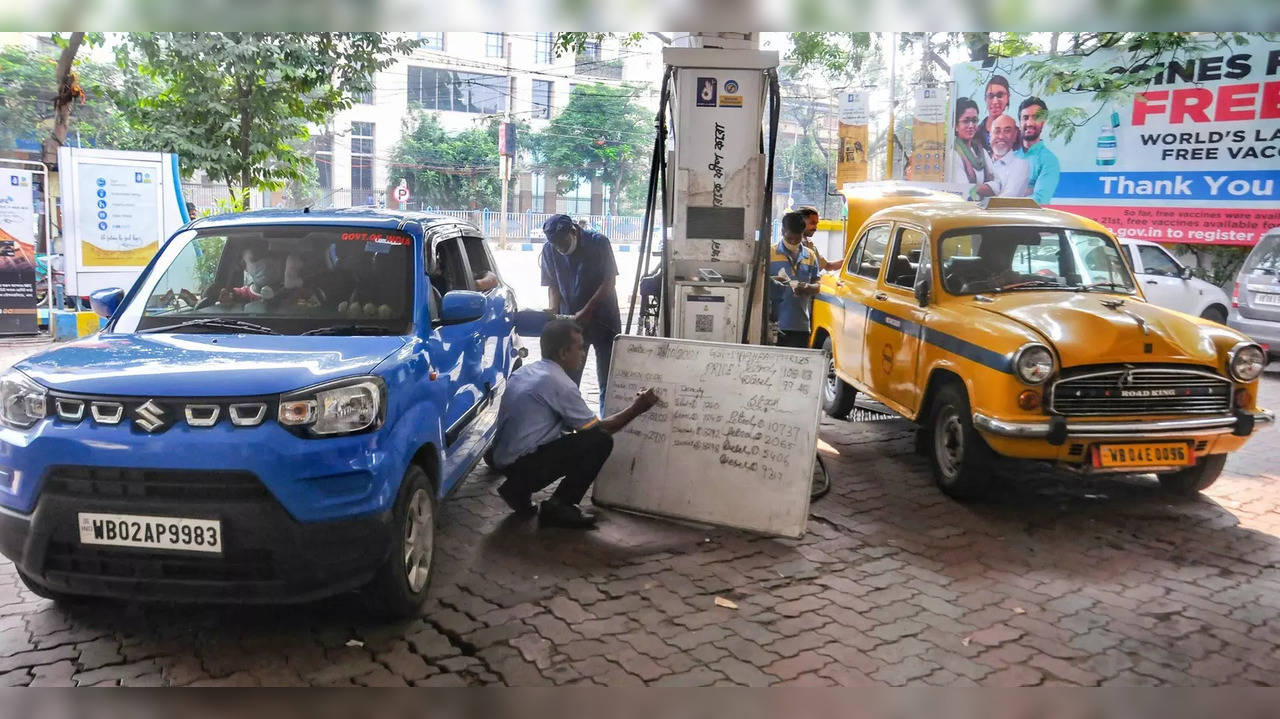 Kolkata: A pump attendent writes the petrol price on a board as diesel and petro...