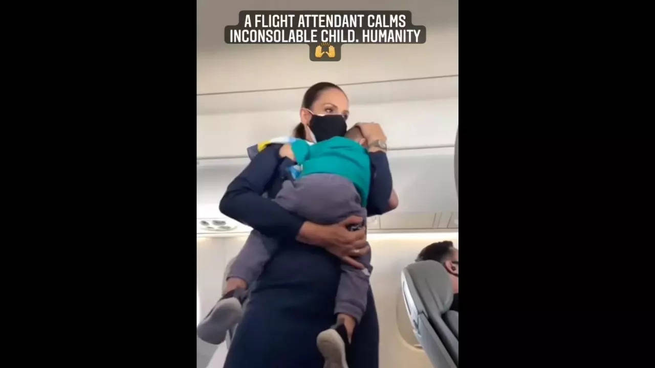 A flight attendant consoles a crying kid. Image courtesy: Instagram