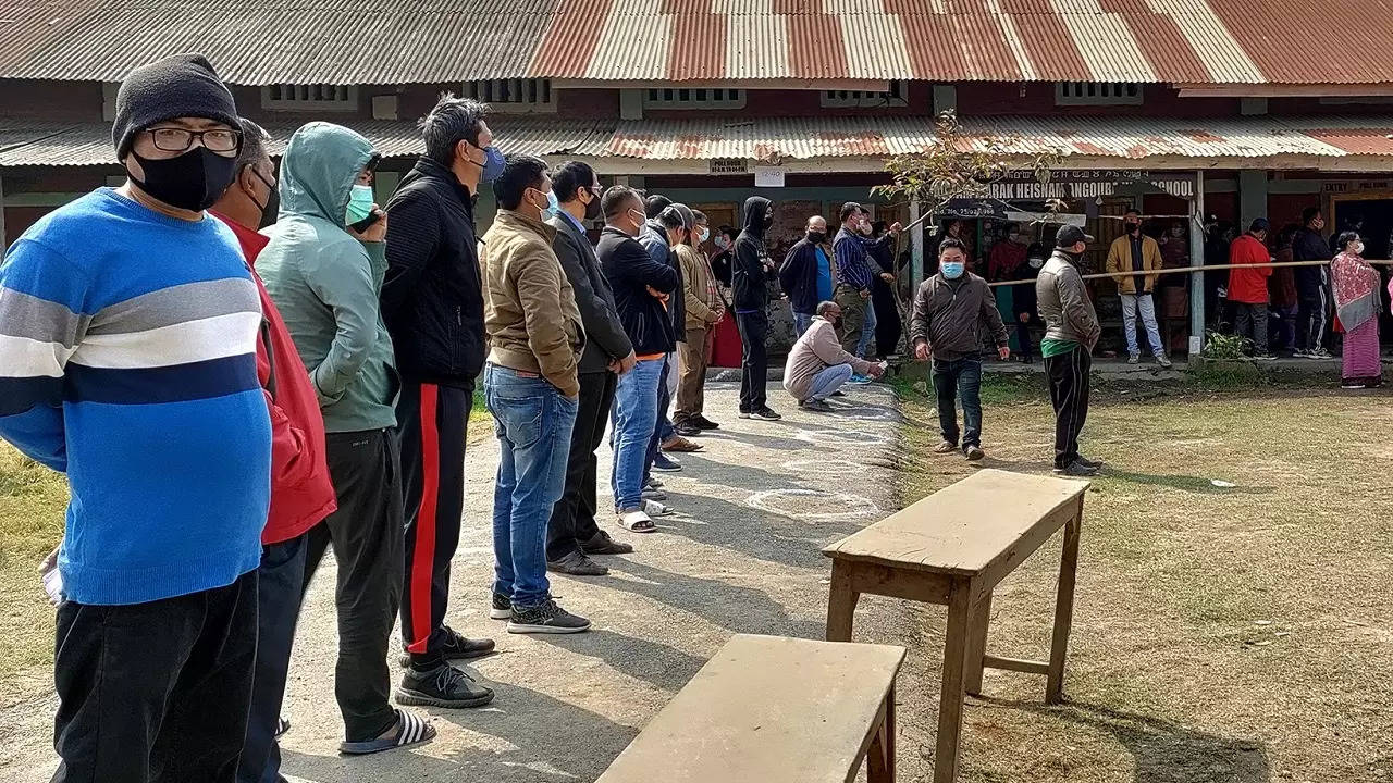 Voters stand in a queue to cast their votes at a polling booth, during the first phase of Manipur Assembly Elections in Manipur